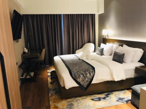 a bedroom with a large bed with white sheets and pillows at Novotel Hotel Residence Manila at Acqua in Manila