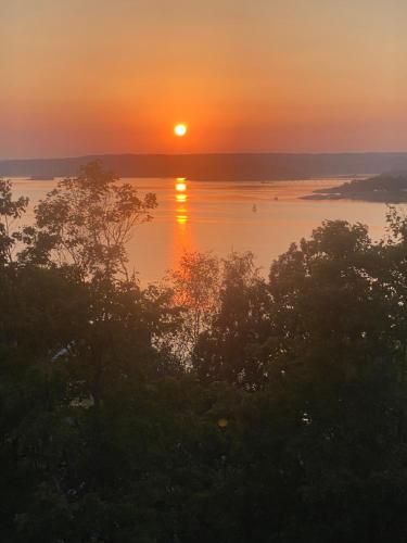 a sunset over a body of water with trees at Fräknero in Ljungskile