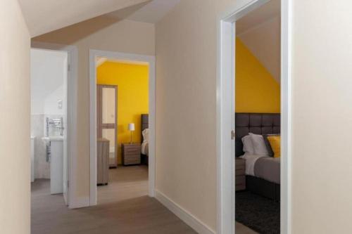 a bedroom with a bed and a yellow wall at SAV Stays Apartments Clarence Street-Loughborough in Loughborough