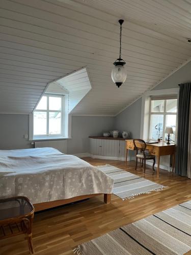 a bedroom with a bed and a table and windows at Fräknero in Ljungskile