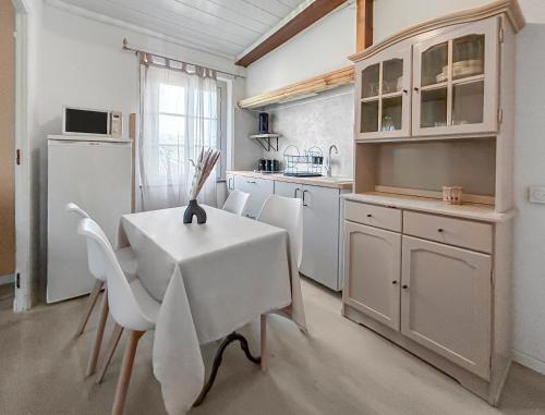 une cuisine avec une table, des chaises et un réfrigérateur dans l'établissement T2 Cosy Vue Sur La Cité, à Carcassonne