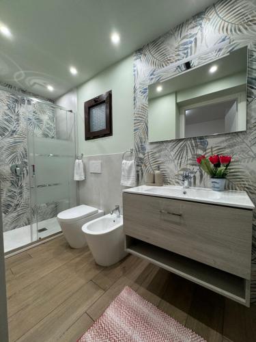 a bathroom with a sink and a toilet and a mirror at Il Tulipano house in Catania