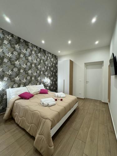 a bedroom with a large bed with a floral wall at Il Tulipano house in Catania