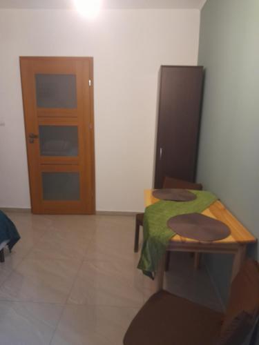 a room with a table and a wooden door at Willa Gracja in Wisła