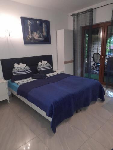 a bedroom with a large bed with a blue blanket at Willa Gracja in Wisła