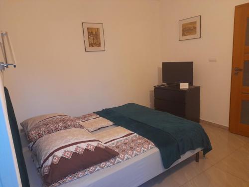 a bedroom with a bed and a tv on a dresser at Willa Gracja in Wisła