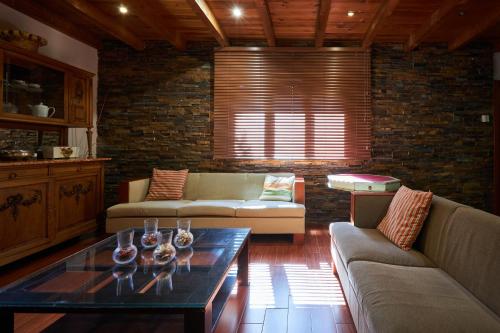 a living room with a couch and a table with wine glasses on it at Preciosa villa rural a poca distancia de Ávila by Alterhome in Velayos