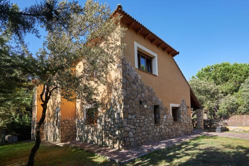 a stone house with a tree in front of it at Preciosa villa rural a poca distancia de Ávila by Alterhome in Velayos