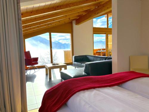 a bedroom with a bed and a living room with windows at SwissHut Stunning Views Alps Lake - Apart Aelenbach in Sigriswil