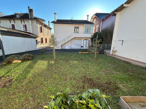 a yard with two trees in the middle of two buildings at Le Chalet - maison avec jardin et parking in Lourdes