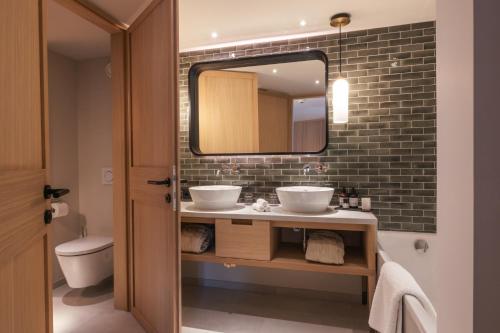 a bathroom with a sink and a mirror at Hotel Berghof in Lech am Arlberg