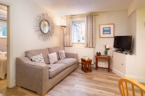 a living room with a couch and a television at Thomas Fold Flat in Ambleside