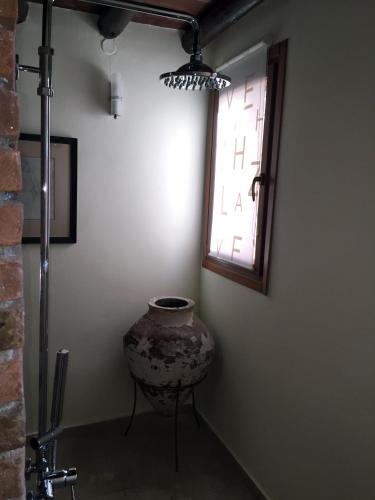 a room with a vase and a window and a chair at Maison Kyriakou in Stavrinídes