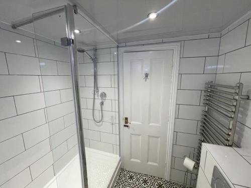 Un baño con ducha y puerta de cristal. en Thomas Fold Flat, en Ambleside