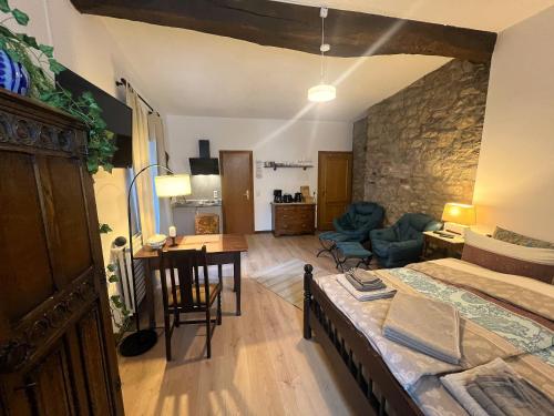 a bedroom with a bed and a room with a table at Apartment Eifelsteig im Posthalterhof, anno 1683, mit Sauna in Blankenheim