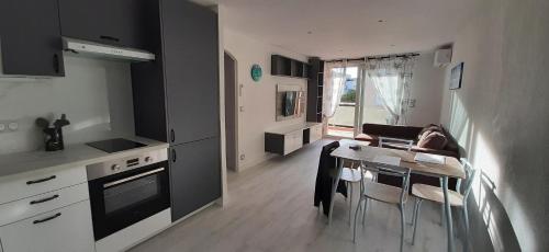 une cuisine et une salle à manger avec une table et des chaises dans l'établissement Baccarat, à Fréjus