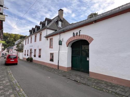 a red car parked in front of a white building at Apartment Eifelsteig im Posthalterhof, anno 1683, mit Sauna in Blankenheim