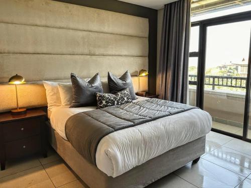 a bedroom with a large bed with pillows on it at Zimbali Suites 307 in Ballito