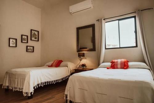 a bedroom with two beds and a window at Grann Posada Xilitla in Xilitla