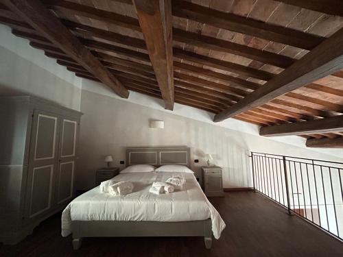 a bedroom with a bed with white sheets and wooden ceilings at Palazzo Contelori in Terni