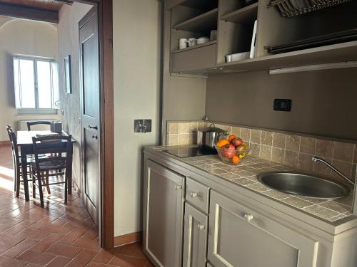 a kitchen with a sink and a bowl of fruit on the counter at Palazzo Contelori in Terni