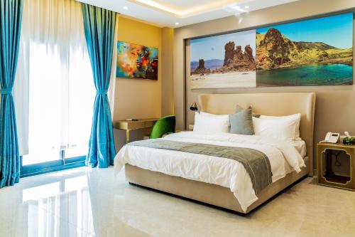 a bedroom with a bed with a large painting on the wall at The Villa Haramous in Djibouti