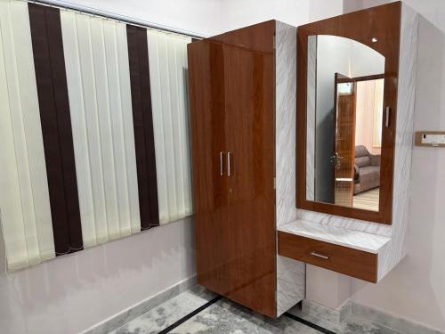 a wooden cabinet with a mirror on a wall at The Divyakashi stay in Varanasi