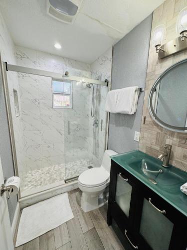 a bathroom with a shower and a toilet and a sink at Sarasota Paradise Heated Pool Home Near IMG & Siesta Key Beach in Sarasota