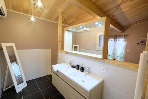 une salle de bain avec un lavabo et un miroir dans l'établissement Villa Combes - Piscine Chauffée & Spa - Grand parc arboré, à Bruniquel