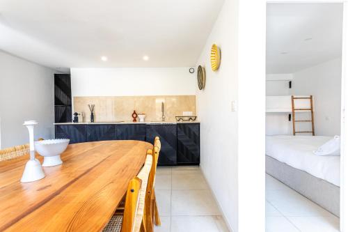 cocina y dormitorio con mesa de madera y cama en Très Bel Appartement aux Goudes, en Les Goudes