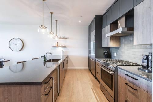 a kitchen with wooden cabinets and a clock on the wall at Luxury Living on the Slopes - Horizon 2-204 in Mont-Tremblant