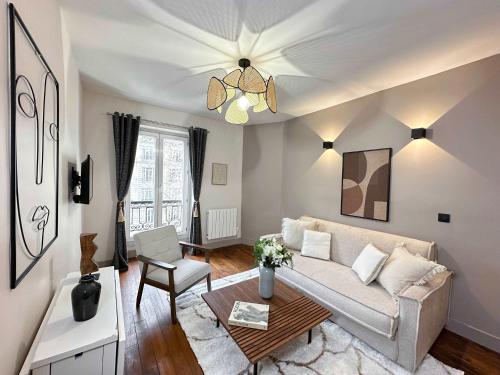 un salon avec un canapé et une table dans l'établissement Arc de Triomphe Cosy Retreat, à Paris
