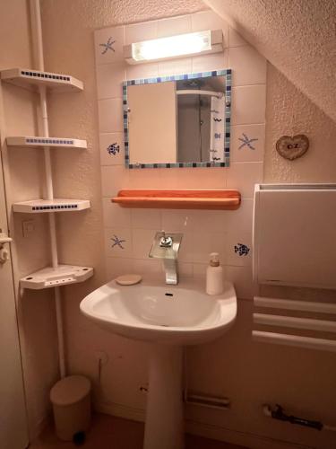 une salle de bain avec un lavabo et un miroir dans l'établissement Ski in-ski out appartement in het centrum van Oz 3300, à Oz