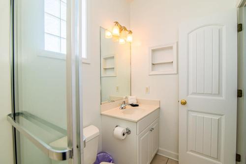 a bathroom with a sink and a toilet and a mirror at Tropical Rays Huge Cherry Grove House w Pool in Myrtle Beach