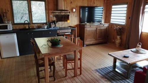 a kitchen with a wooden table and a dining room at Maison bois vue Causse Larzac et viaduc in Millau