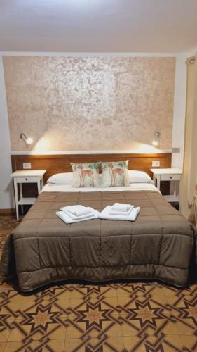 a bedroom with a bed with two towels on it at Locanda Il Gigante in Collagna