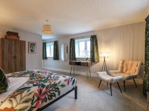 ein Schlafzimmer mit einem Bett, einem Waschbecken und einem Stuhl in der Unterkunft Barley Cottage in Huntingdon