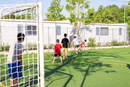 a group of children playing soccer on a soccer field at Cesenatico Camping Village in Cesenatico
