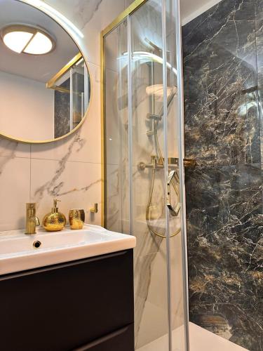 ein Badezimmer mit Glasdusche und Waschbecken in der Unterkunft Apartament w Rynku - Duszniki- Zdrój in Duszniki-Zdrój