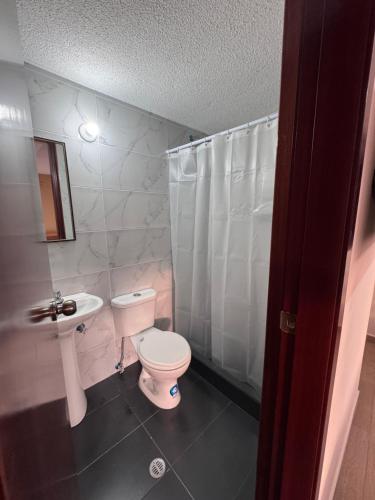 a bathroom with a toilet and a sink and a shower at Hotel Casa Colonial Montufar in Quito