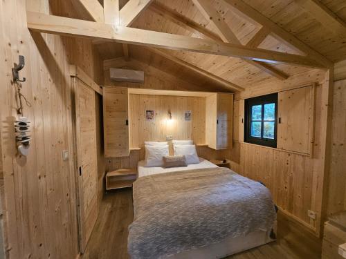 une chambre avec un lit dans une cabane en bois dans l'établissement CITY NATURE Lescar Pau, à Lescar