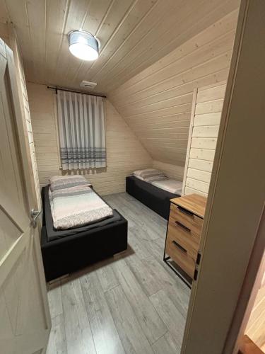 a small room with two beds and a wooden floor at Skrzynia in Skrzynia