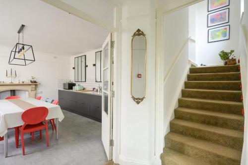 a kitchen and dining room with a table and red chairs at 19th Century House Private Parking nr Painswick in Painswick