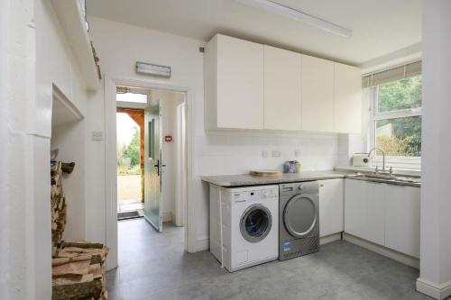 a kitchen with a washing machine and a sink at 19th Century House Private Parking nr Painswick in Painswick