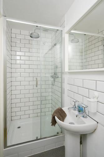 a white bathroom with a sink and a shower at 19th Century House Private Parking nr Painswick in Painswick