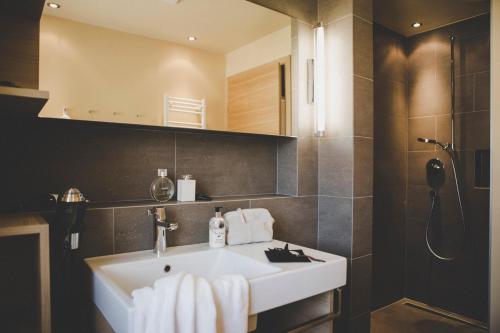 a bathroom with a white sink and a shower at Arabella Retreat & Spa in Nauders