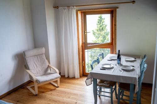 a dining room with a table and a chair and a window at Casa Caravino in Varenna