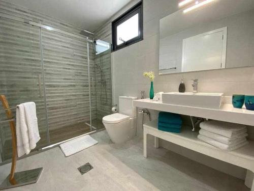 a bathroom with a toilet and a sink and a shower at Shangri Sol - Holiday house in Arco da Calheta