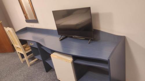 a blue desk with a television on top of it at Hostel Elena in Sofia