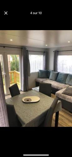 un salon avec une table et un canapé dans l'établissement Mobil home, à Onzain